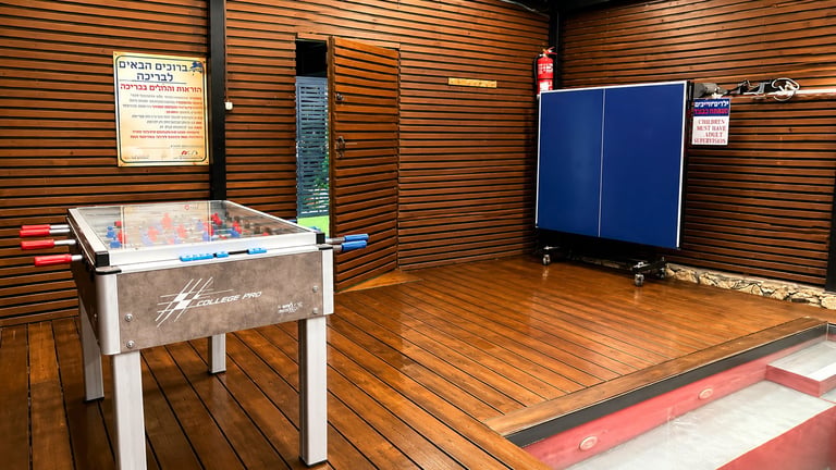 Recreation room with foosball table, ping pong table, and wooden floor and walls